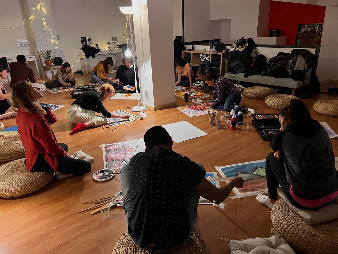 Artistas dibujando juntos en el suelo durante una sesión de Co-Create