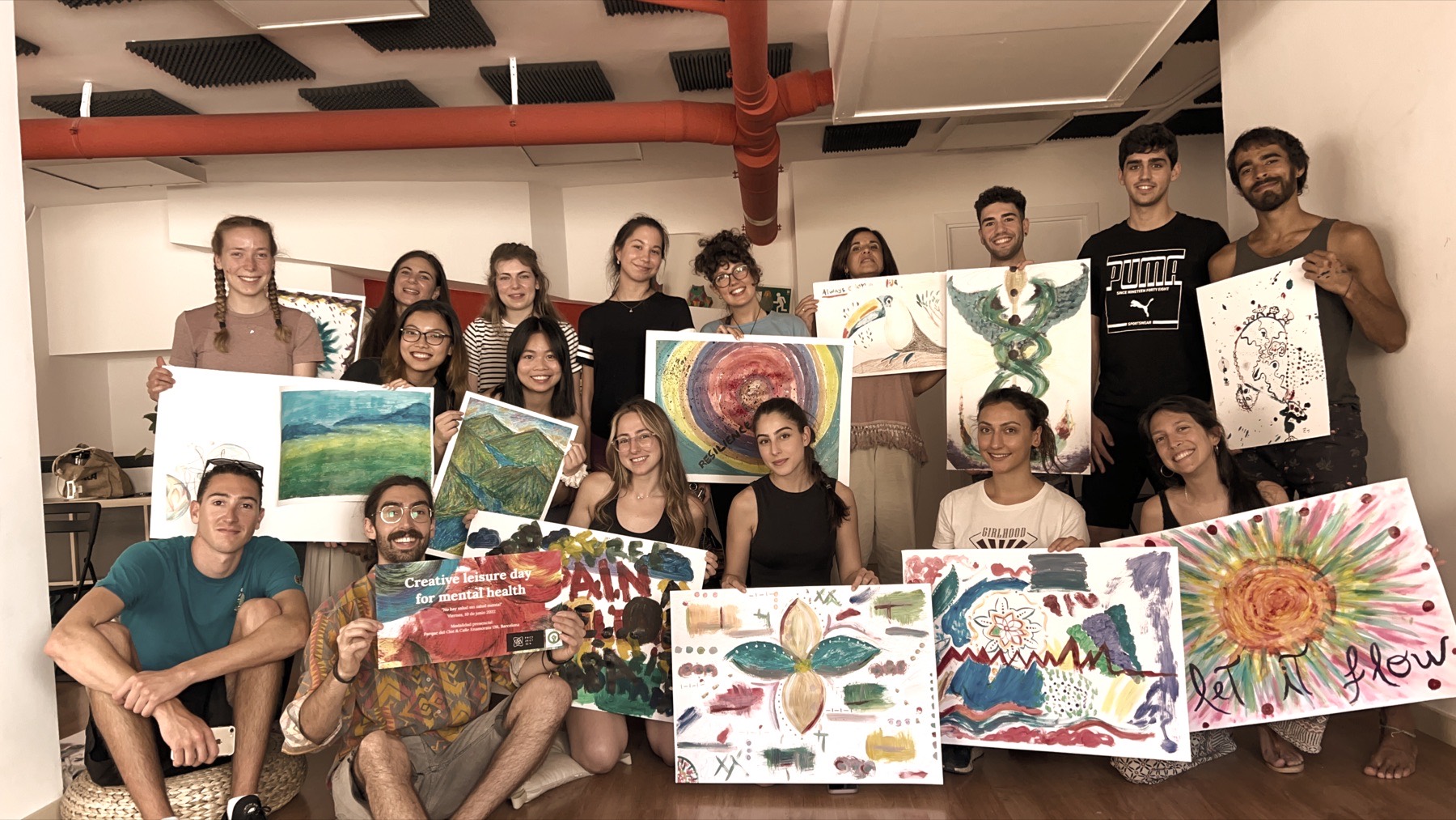Young people holding up their paintings after a Project IN session